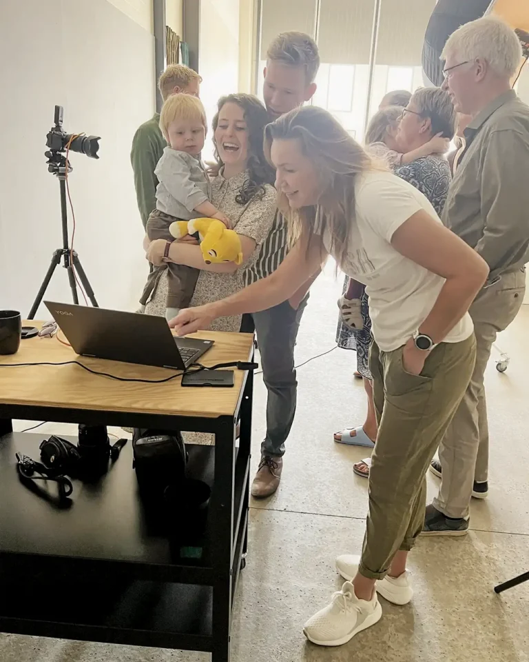 fotograf-i-aarhus-kirsten-adler i studiet, hvor hun kigger på de billeder med familien, hun netop har taget billeder af.